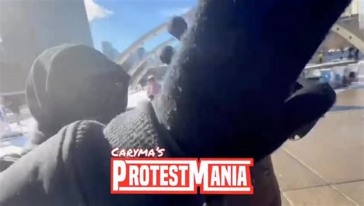 Masked Antifa activists pursue my videographer through a corporate carnival-style game at Nathan Phillips Square, disrupting the promotional display. Police appear absent, despite several officers stationed near the counterprotest on the sidewalk. Could this be a factor in the reported decline of businesses willing to engage in city-level sponsorships? 📸 Feb 7, 2026 #Toronto #ProtestMania Help fund fearless on-the-ground coverage of Canada’s Antifa movement: ProtestMania.com | Caryma Sa’d