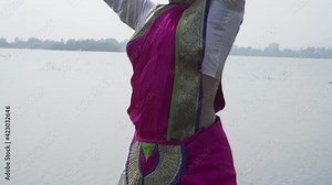 A bharatnatyam dancer displaying a classical bharatnatyam pose in the nature of Vadatalav lake, Pavagadh. Beautiful indian girl dancer in the posture of Indian classical dance bharatanatyam .