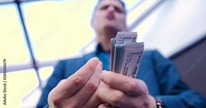 Young guy businessman freelancer counts money. Close-up hands counting a stack of money. Dollars, income, finance, business, suit