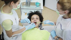Oral hygiene and dental care: Doctor dentist and assistant working with patient in dental clinic