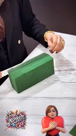 DETALLE FLORAL PARA SAN VALENTÍN ❤️🌸✨ Fíjate cómo crear un detalle floral precioso y muy elegante para San Valentín 💕. Usamos medio oasis en forma de rectángulo y lo forramos con papel de floristería de dos colores, doblando una esquina para formar un bonito triángulo decorativo. Dejamos la parte superior libre para colocar muchas florecitas a nuestro gusto 🌷✨. Terminamos con una cinta decorativa alrededor y una etiqueta con mensaje especial… ¡y listo! Un detalle romántico y perfecto para reg