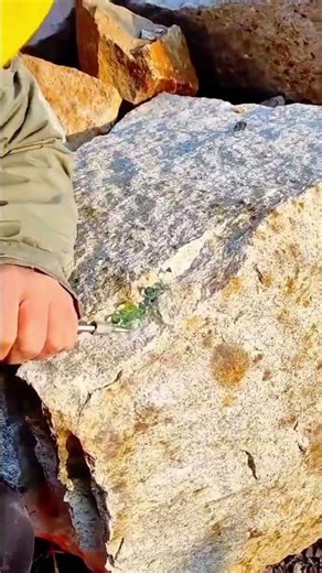 A Worker carefully chiseling a large stone block to shape it with precision under bright sunlight