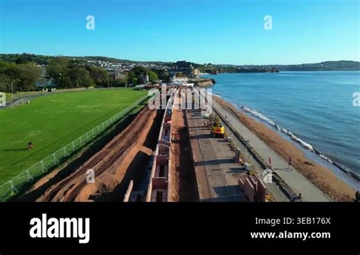 Paignton, Devon, England: DRONE VIEWS: A sea defence wall under construction on Paignton Green. The project will be completed in 2027 to protect seafront properties from global rising sea levels. Paignton is a popular UK holiday destination Stock Video Footage - Alamy