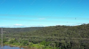 Aerial footage of transmission tower power lines running across a river