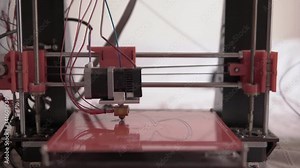 Front view of a 3D printer working on a project of a face mask design concept model made out of plastic filament to deliver to healthcare staff against virus
