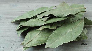 Dried whole bay leaves on cutting board Laurus nobilis