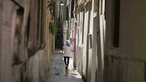 Woman washing the street with hose