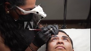 Male micro blading procedure to making permanent eyebrows makeup in a beauty salon