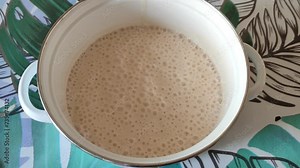 Dough fermentation with a bubbles. Process of raising the dough in the saucepan.