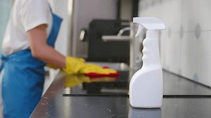 Cleaning service woman cleaning in kitchen at home. Young housekeeper cleaner wiping messy dirty cooking counter for housekeeping housework or chores. Female clean stove with detergent. Realtime