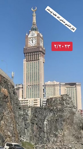 Ornate Clock Tower with Arabic Calligraphy in Clear Sky