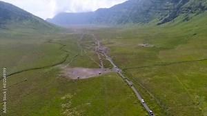 Malang East Java, Indonesia. The view of the jeep crossing Savana Bromo and Teletubbies Hill on Mount Bromo using a drone.