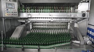 The technological process of washing bottles in the washing machine. Automated washing of glass bottles in the shop for bottling alcoholic beverages. Technological line for bottling of beer in brewery