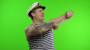 Young sailor man dances and celebrates. Seaman guy in sailor's vest. Chroma key