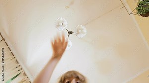A little girl opening a cardboard box with a gift inside, screaming with joy and happiness, grabbing the contents.