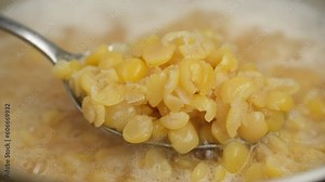 Cooking yellow split peas in boil water. Chef stir boiling yellow split peas with spoon