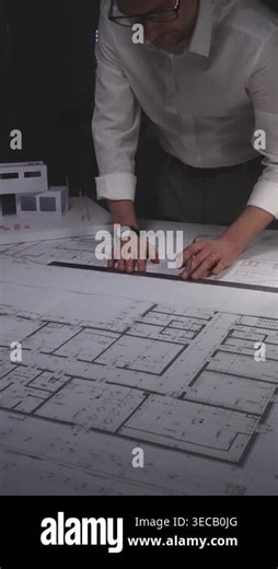 Architect drawing details on house blueprints, working with a building model and tools for architecture and engineering plans. Concept of architecture and business in low key lighting Stock Video Footage - Alamy