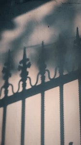 clip-3602932853-shadows-fence-create-geometric-patterns-on-wall