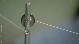 Thread Feeding A Sewing Machine in Textile Industry. Close Up.