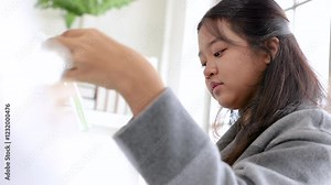 Senior teacher teaching Asian elementary boys and girls young kids students studying in laboratory science classroom mix liquid substance experiments, education learning by doing in private school