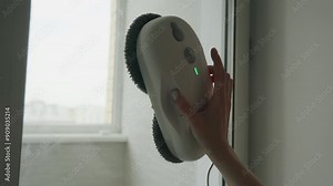 Robot meticulously scrubs the glass surface of a high-rise window, showcasing advanced cleaning technology in action.