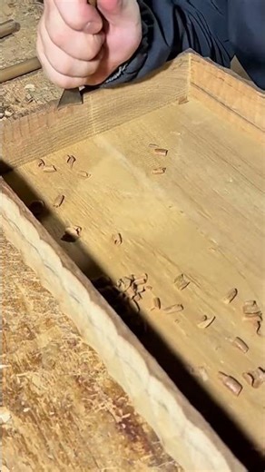 polishing a flat cream wood surface on a brown table using a manual engine power tool for the work