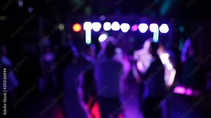 Dancing late at night in a nightclub. Young people dance to cheerful positive music against a background of light effects.