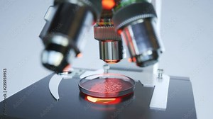 A modern microscope in a sterile lab room analyzing samples on a petri dish 4KHD