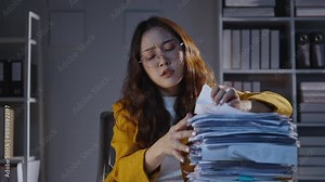 Professional office worker sorting through a large pile of documents in a busy office, organizing and examining papers at a desk. Stressful workday scene