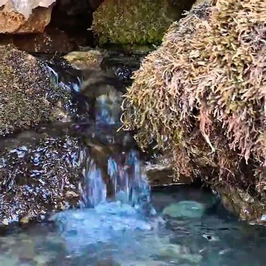 Water spring inside a rock in the mountains , sound of water
