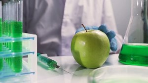 clip-1021451836-bio-scientist-gloves-injects-green-solution-substance