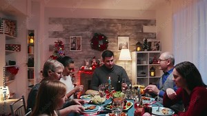 Happy big family with different ages celebrating christmas with traditional food. Traditional festive christmas dinner in multigenerational family. Enjoying xmas meal feast in decorated room. Big