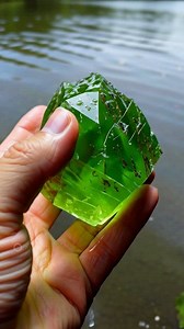A natural raw demantoid garnet gemstone, displaying an emerald green color. | Gemstone and jewelry