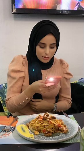 Woman Enjoys Spaghetti at Restaurant Table