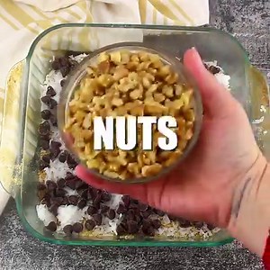 These bars will disappear quicker than you can say MAGIC! 7- Layer Magic Cookie Bar! Chocolate Chips, nuts, and coconut caramelize on a graham cracker crust. GET THE FULL RECIPE: https://mooreorlesscooking.com/2013/12/27/magic-bars/ | Moore or Less Cooking Blog