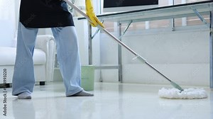 Woman is cleaning the office room in the company, she is sweeping the work desk, floor and glass with cleaning equipment to keep the company clean and organized. Office cleaning concept.