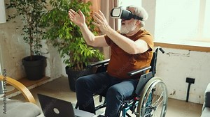 Exploring new digital gadgets. Senior man sitting in wheelchair, wearing VR glasses, taking virtual adventures at home. Innovations. Concept of healthcare, lifestyle, motivation, wellness, technology