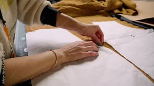 Clothing making pinning sewing pattern templates to fabric. wide shot