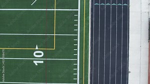4K aerial of an American turf football field moving toward the ground