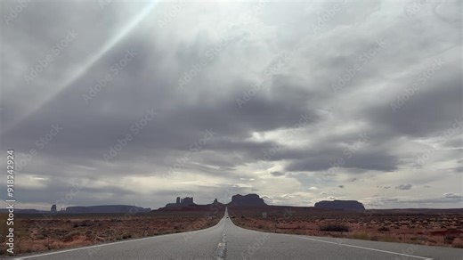 The iconic Monument Valley road from Forrest Gump Point in Utah, USA. Taken on a cloudy, hazy day with an atmospheric mood. Symbolic of the wild west and desert road trips. Stock Video