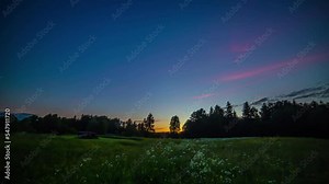 Elapsing of period of time from dawn to dusk over fresh green meadows. Time lapse.