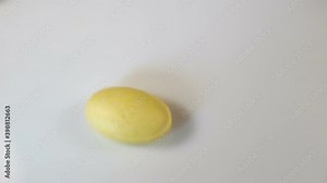 Lemon oval pressed vitamins without a shell are shifted to the side, one tablet rotates around its axis. Real time, copyspace, natural light, close-up, on a white background