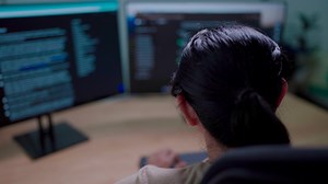Download Close-up of IT woman working on desktop computer in data center control room Young professionals writing about programming code languages for free