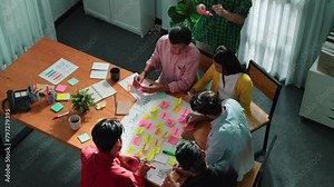 Close up of professional business team hands writing and putting sticky note on scrum task board. Top view of project manager write task and use kanban board to manage time and workflow. Convocation.