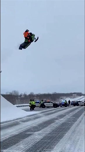 Snowmobile jumps over cops on highway