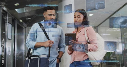 Woman tapping tablet with man in lobby, holograms overlaying tablet while both checking travel plan