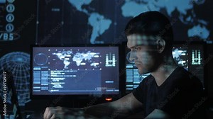 Male hacker programmer working at computer while blue code characters reflect on his face in cyber security center filled with display screens. Stock Video
