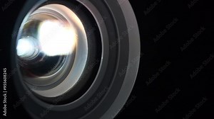 Cinema hall. Movie is shown through projector. Lenses of working projector change color. Close-up of a working projector lens. Light of different colors passes through lenses