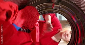 View from inside the washing machine drum. Housewife puts the Laundry capsule in the drum of the washing machine. Housekeeping and home improvement concept.