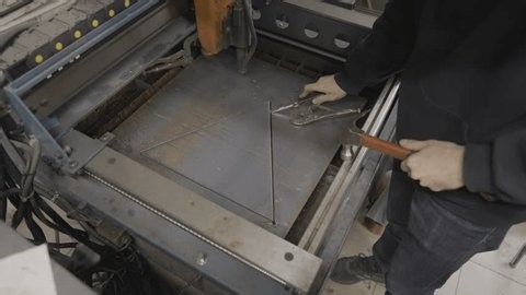 clip-3990361499-workshop-worker-removes-triangle-cut-out-sheet